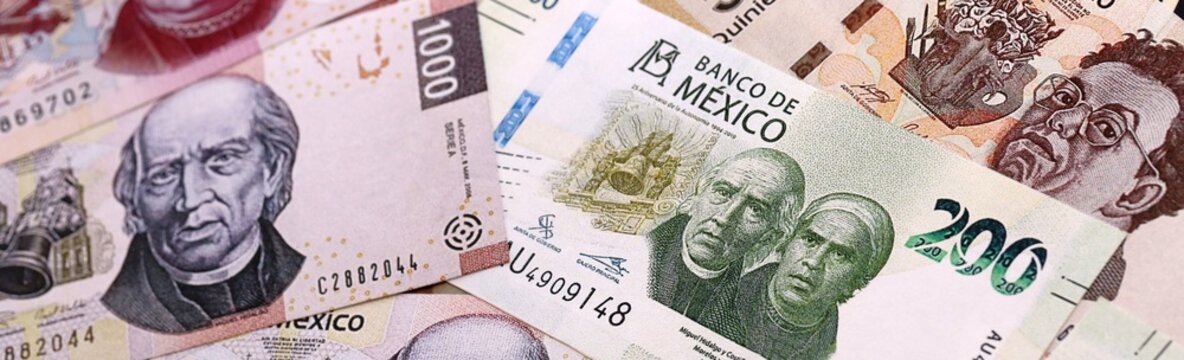 Mexican peso money bills pile on table. Mexico banknotes of MXN currency close up.