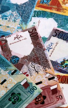 Qatari riyal money bills pile on table. Qatar banknotes of QAR currency close up.