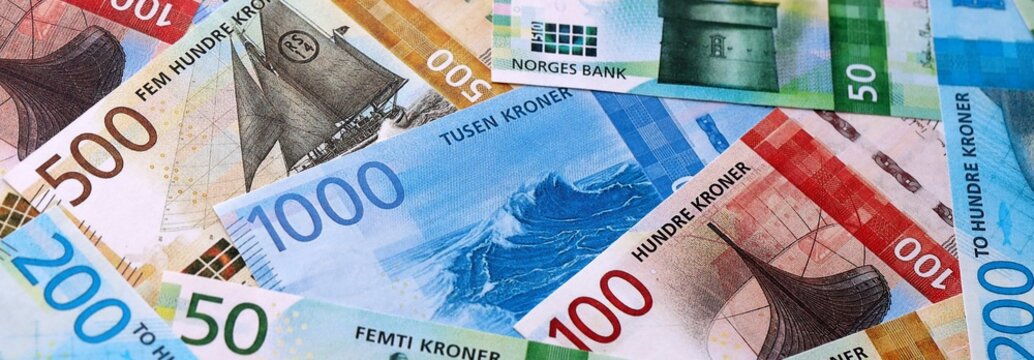 Norwegian krone money bills pile on table. Norway banknotes of NOK currency close up.
