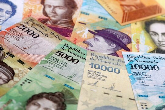 Venezuelan bolivar money bills pile on table. Venezuela banknotes of VES currency close up.
