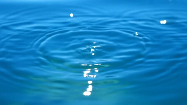 Mesmerizing slow motion capture of a water droplet creating a beautiful crown shape as it impacts the surface