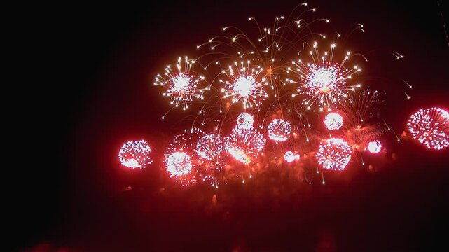 The night sky explodes with vibrant displays. Bursting pyrotechnics illuminate the darkness during the New Year celebration. Sparkling trails paint the air with color.
