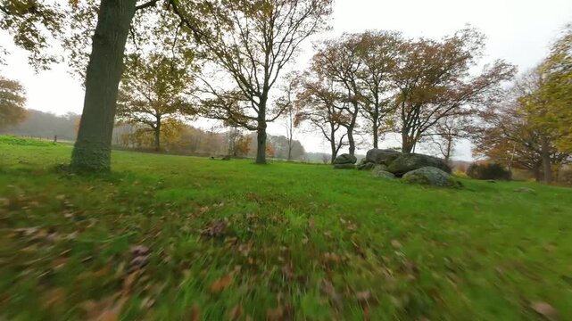 Flying past ancient dolmen and autumn trees