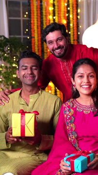  Indian family of four dressed in traditionals celebrates diwali with diyas , gifts and love in their beautifully decorated home creating cherished memories together