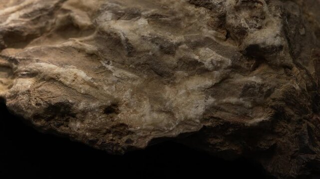 Close-up eroded rock surface with soft shapes and earthy texture