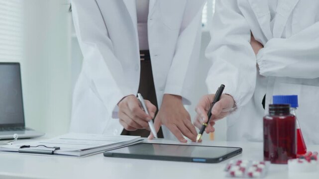 Medical Professionals Reviewing Tablet Treatment Chart in Clinical Office Healthcare Environment Focus on Technology and Collaboration