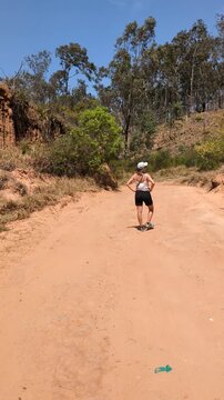 Woman Hiker on Dusty Dirt Road near Samaipata, Bolivia. Female Traveler Exploring Rural Trails in Santa Cruz Highlands, Adventure and Active Lifestyle in South America.