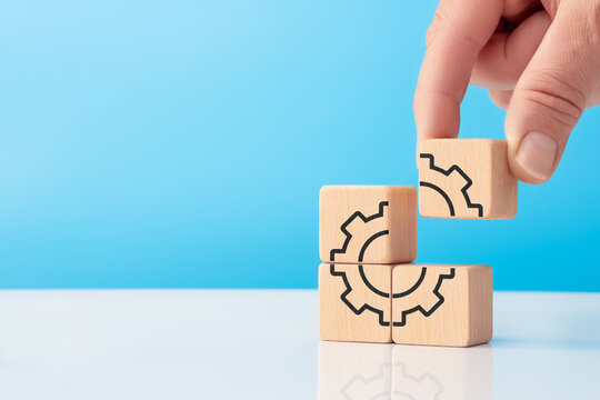 Hand placing final cube with gear icon for business automation