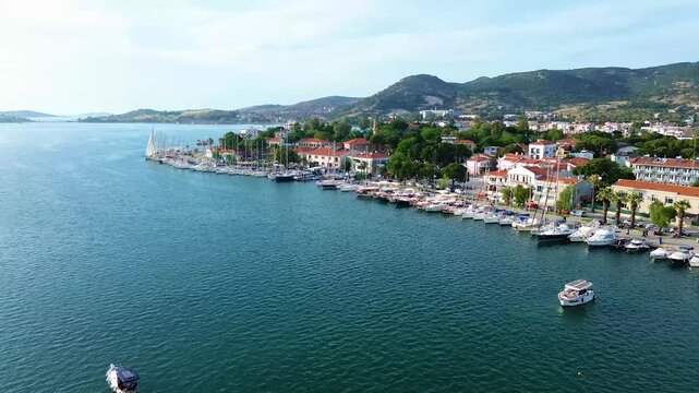Aerial view of a bustling harbor filled with sailboats and a small motorboat. Turkey, Izmir, Eski Foca