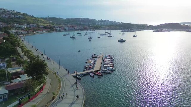 Aerial view of a bustling harbor with boats and a scenic coastal town. Turkey, Izmir, Eski Foca