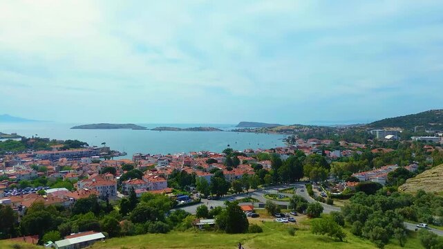 Aerial view of a coastal town with red-tiled roofs and a blue sea. Turkey, Izmir, Eski Foca