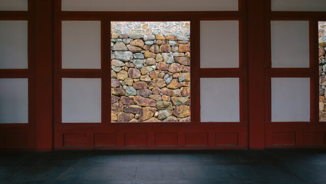 Korean Traditional House partial view with white wall, red beams, wooden floor called Maru
