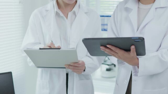 Medical Professionals Reviewing Tablet Treatment Chart in Clinical Office Healthcare Environment Focus on Technology and Collaboration
