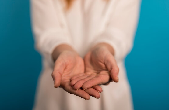 Woman's hands outstretched, palms up, offering something. Concept of giving, asking, receiving, and