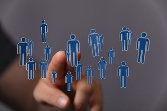 Hand pointing at a network of digital human icons, symbolizing connection, teamwork and collaboration. Ideal fo