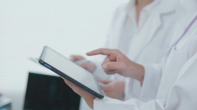 Medical Professionals Reviewing Tablet Treatment Chart in Clinical Office Healthcare Environment Focus on Technology and Collaboration