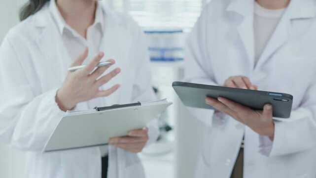Medical Professionals Reviewing Tablet Treatment Chart in Clinical Office Healthcare Environment Focus on Technology and Collaboration