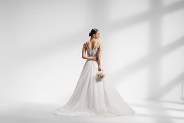 Naklejka premium Elegant bride shot from behind in a studio