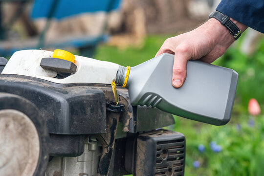 Filling a cultivator with motor oil and servicing garden equipment