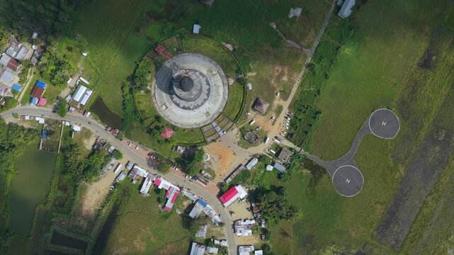 Cinematic topdown aerial shot of the worlds largest Shivalinga at Maha Mrityunjaya Temple in Nagaon, Assam, India. Showcases unique spiritual architecture and surrounding rural landscape.