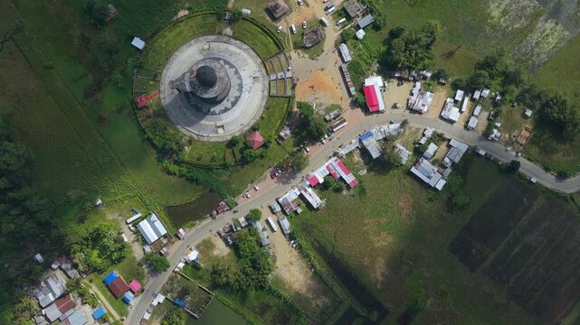 Cinematic topdown drone shot of the worlds largest Shivalinga at Maha Mrityunjaya Temple in Nagaon, Assam, India. Showcases authentic architecture and surrounding rural landscape.