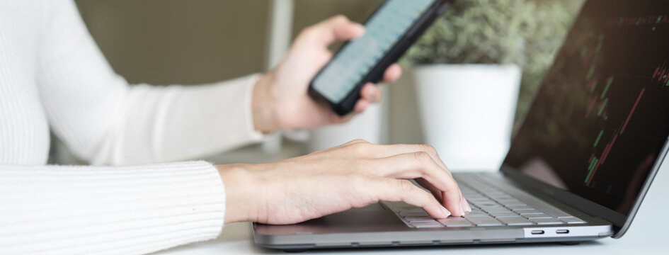 Financial investment in exchange stock concept, Young woman investor looking at laptop monitor to research the stock market on the digital marketplace platform at home.