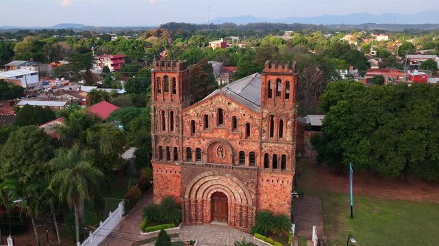 Pan right aerial showcasing the iconic Nuestra Se&ntilde;ora de la Asunci&oacute;n de Ybaroty church with red brick twin towers in Villarrica, Paraguay