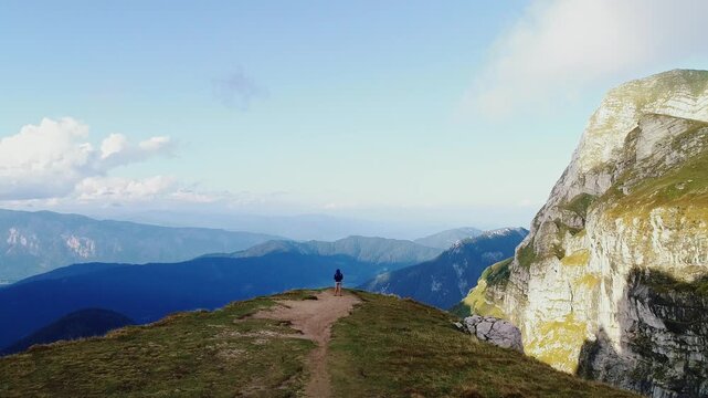 Aerial drone flying forward over man on Mangart saddle with alpine sunset Italy