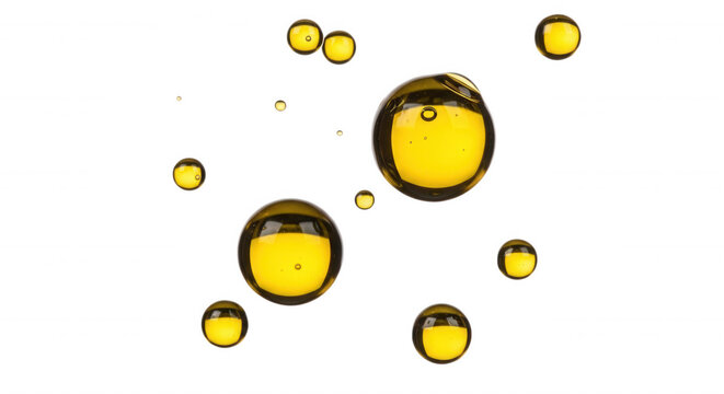 Floating yellow liquid spheres and bubbles isolated on a solid black background, macro of oil droplets in water