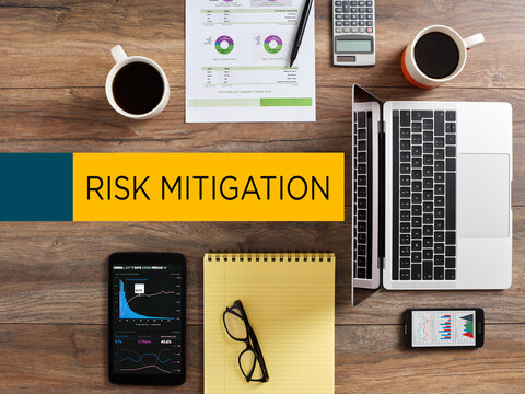 Risk mitigation concept with business tools on a wooden desk