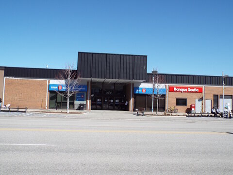 Gatineau, Quebec, Canada &ndash; April 18, 2026: A brick commercial building features signs for "BMO Bank of Montreal and Banque Scotia" under a clear blue sky outdoors at 320 Boulevard Saint-Joseph.