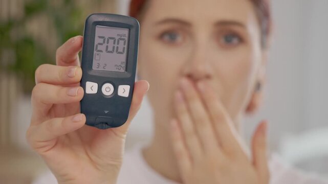 A woman holds a glucometer with a reading of 200 mg dL. This indicates a high blood sugar level that can impact health. Understanding glucose levels is essential.