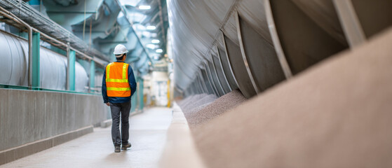 Fototapeta premium Worker inspecting industrial conveyor system