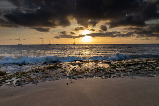 A spectacular sunset over the golden sand and Atlantic ocean seen from the popular Bikini beach at the island of Sal in Cape Verde. It is a nice stretch of beach with a calm cove area that's great for