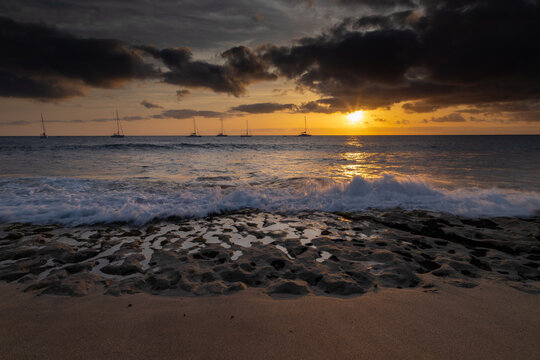 A spectacular sunset over the golden sand and Atlantic ocean seen from the popular Bikini beach at the island of Sal in Cape Verde. It is a nice stretch of beach with a calm cove area that's great for