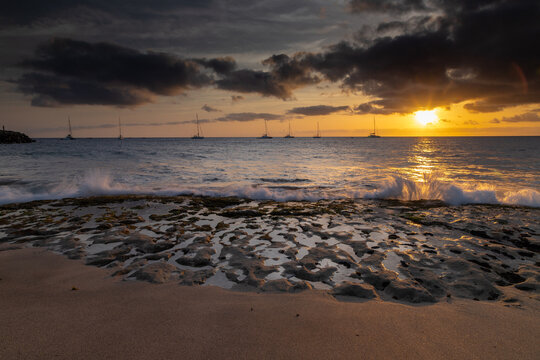 A spectacular sunset over the golden sand and Atlantic ocean seen from the popular Bikini beach at the island of Sal in Cape Verde. It is a nice stretch of beach with a calm cove area that's great for