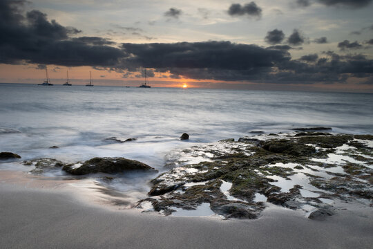 A spectacular sunset over the golden sand and Atlantic ocean seen from the popular Bikini beach at the island of Sal in Cape Verde. It is a nice stretch of beach with a calm cove area that's great for
