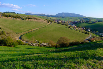 Obraz premium View of a green valley in Slovakia, with a road and isolated houses