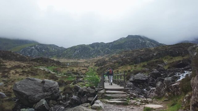 Hikers Crossing the Footbridge to Cwm Idwal, Ogwen Valley, Eryri (Snowdonia)