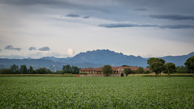 Vecchia cascina tra campi coltivati e sullo sfondo il monte Resegone