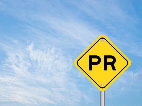 Yellow transportation sign with word PR (Abbreviation of purchase requisition or public relations) on blue color sky background
