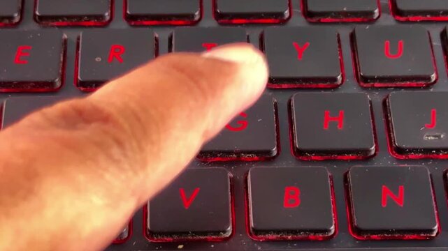Close-up footage of hand interacting with laptop keyboard in "G" button, perfect for office, freelance, and online work content.