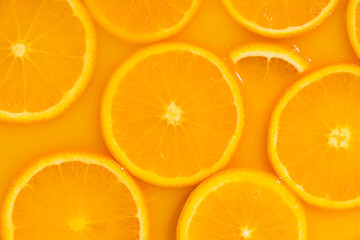 Fototapeta premium Abstract background of orange slices covered with juice.