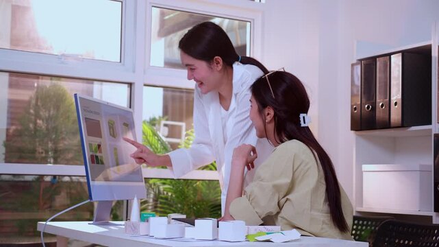 Two young asian businesswoman celebrating watching computer monitor with design cosmetic product success and high five, happy woman and colleagues winning project result together at home office.