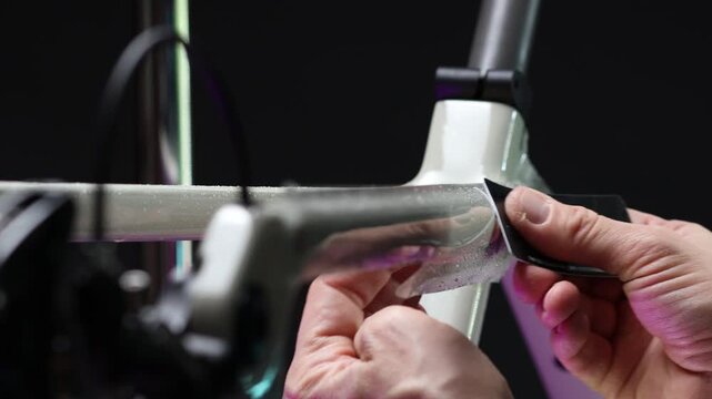 Applying bike protection film on bike frame.