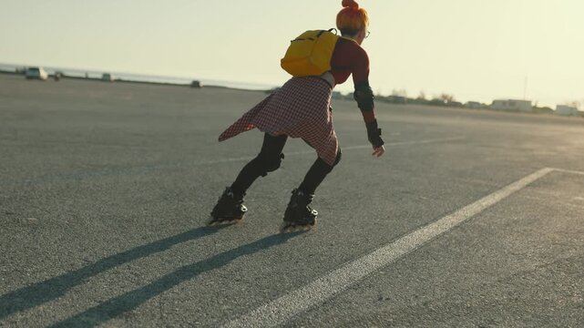 Young woman rollerblading into the sunset
