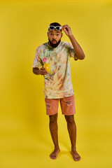 Naklejka premium Vibrant young man enjoying a refreshing drink in a colorful summer setting