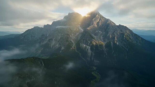Mist-covered mountain peak with cloud veils and jagged rock valleys