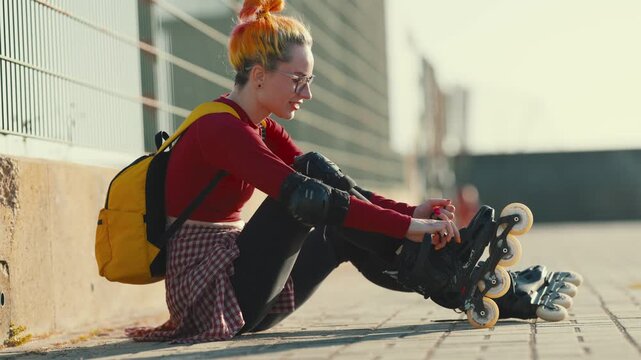 Young woman tying laces on roller skates