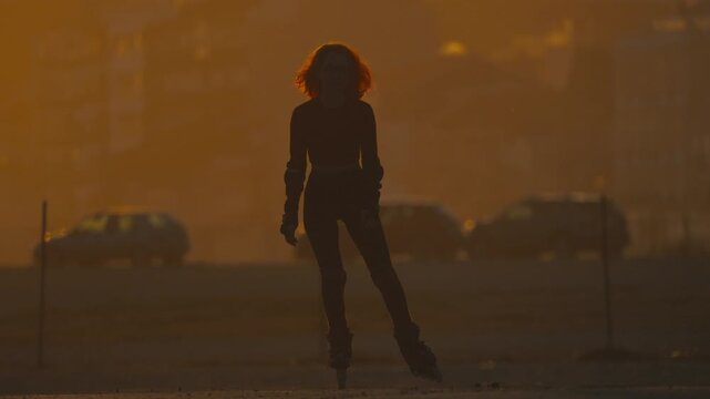 Silhouette of a woman rollerblading at sunset